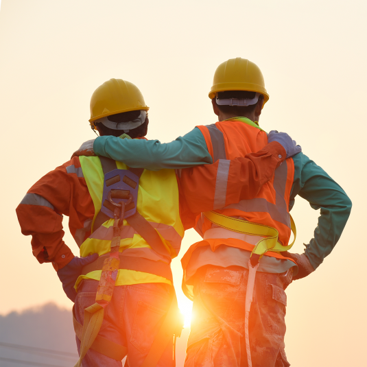 Worker on construction site in the backlight of the setting sun